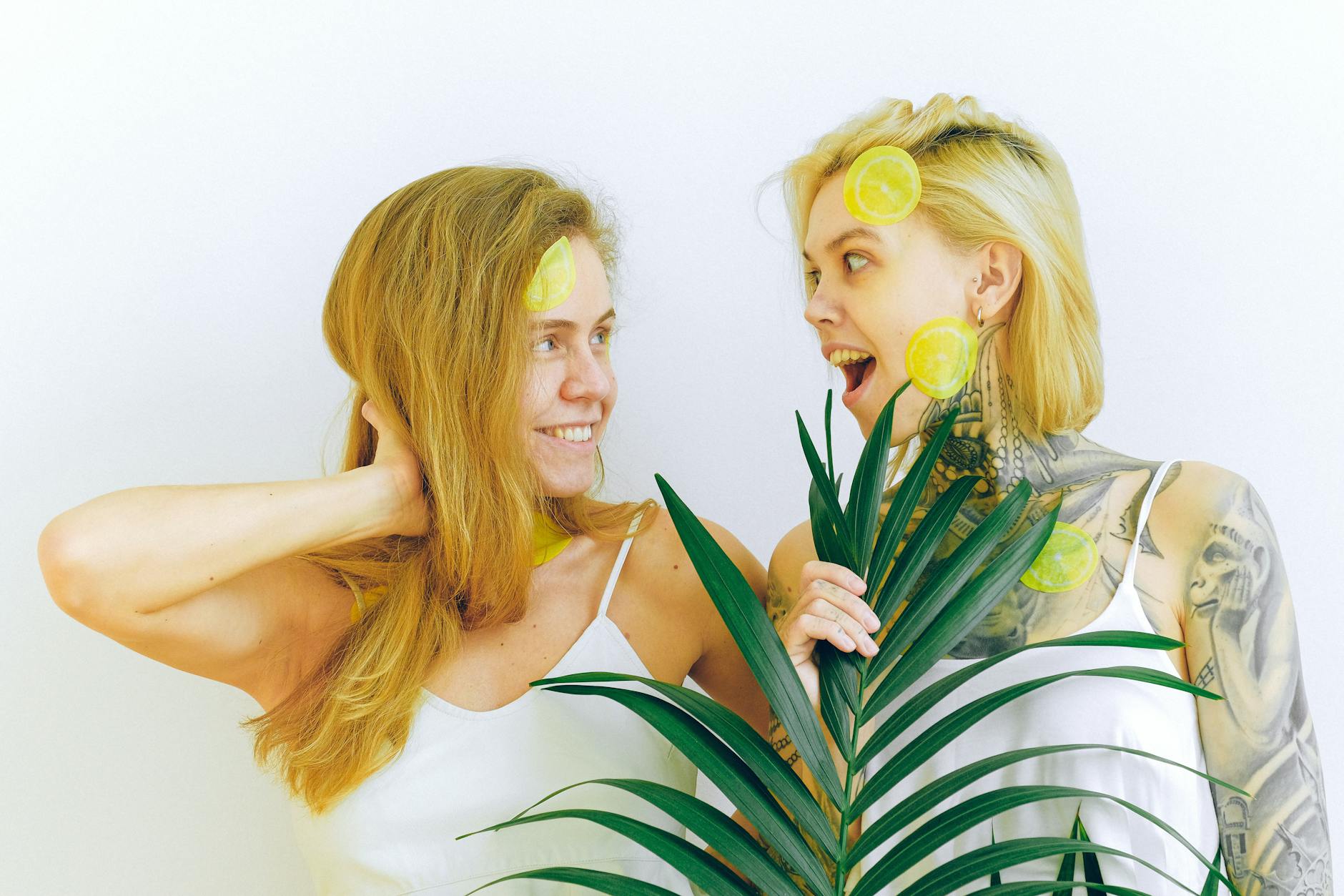 Due donne sorridenti che condividono un momento di gioia e connessione, con dettagli freschi e naturali