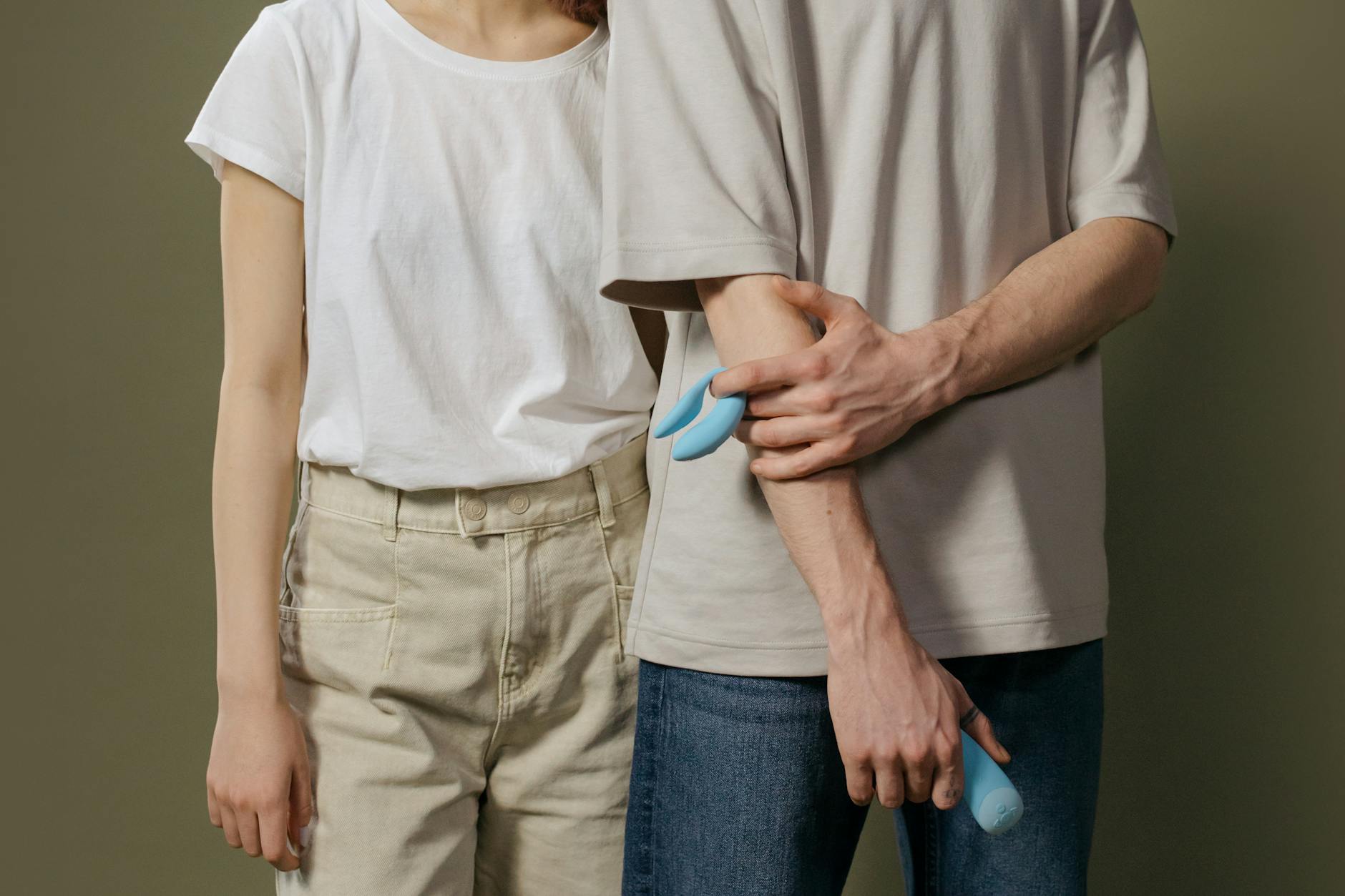Mani che tengono delicatamente un vibratore blu acceso su sfondo viola, simbolo di intimità personale e autodeterminazione sessuale