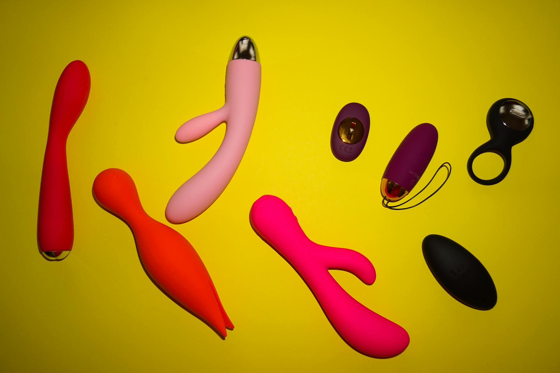 Mano che tiene un vibratore in silicone blu su sfondo viola, simbolo di auto-amore e sessualità consapevole